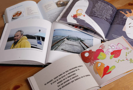 Foto de varios libros abiertos con el interior impreso en color.