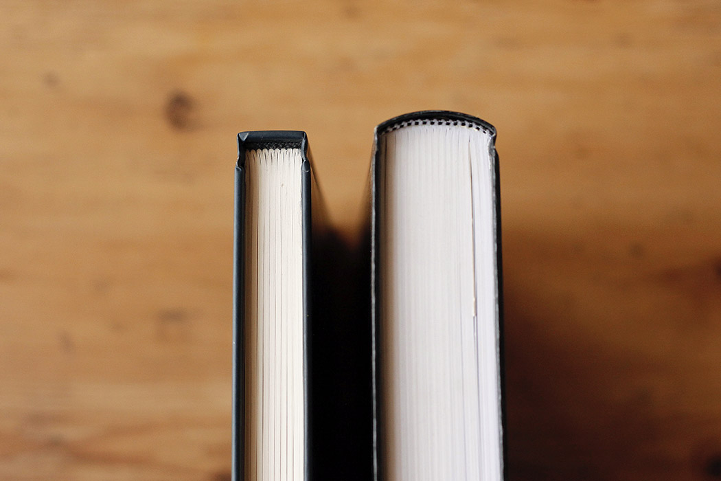 Foto de dos libros en tapa dura para apreciar la diferencia entre lomo recto y lomo redondo.