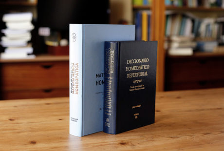 Foto de dos libros encuadernados en tapa dura guaflex: uno con pasta negra y letras doradas; otro con pasta azul celeste y letras negras.